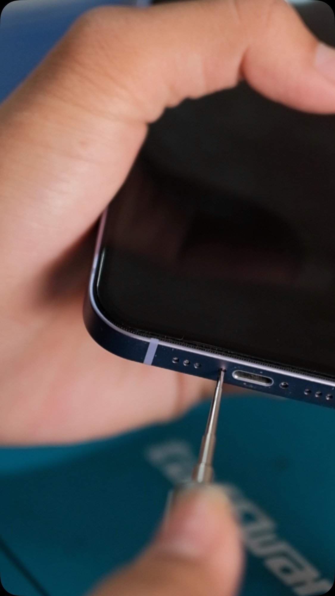 Tangan teknisi Kayfa menangani iPhone dengan obeng presisi